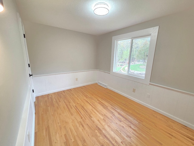 13801 Lake Street Ext, Minnetonka, MN 55345 - spare room with light wood-style floors, wainscoting, and a textured ceiling