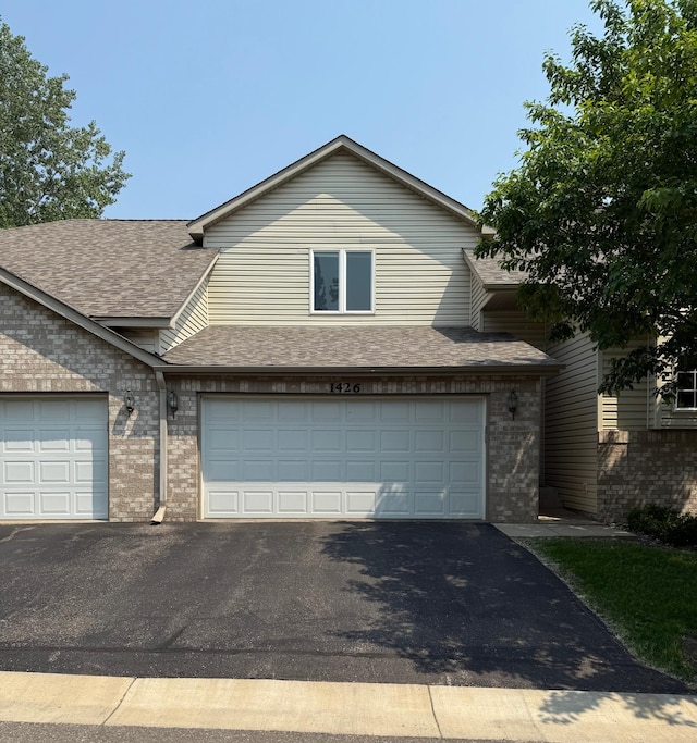 1426 Mcandrews Rd E Unit 30, Burnsville, MN 55337 - view of front of house with brick siding, roof with shingles, asphalt driveway, and an attached garage
