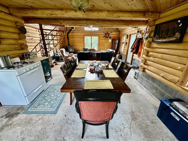 3274 County Road 1 SW, Boone Twp, MN 56623 - dining area with rustic walls, wooden ceiling, a wood stove, and carpet floors