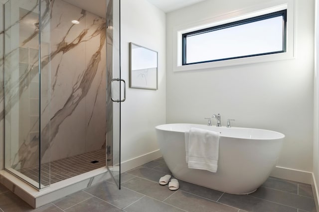 5240 Polaris Ln N, Plymouth, MN 55446 - bathroom featuring baseboards, a freestanding bath, a marble finish shower, and tile patterned flooring