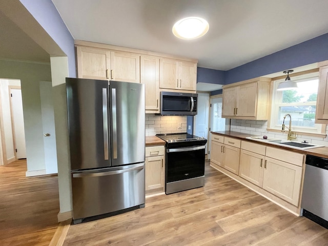 4241 Tyler St NE, Columbia Heights, MN 55421 - kitchen with appliances with stainless steel finishes, tasteful backsplash, light wood-style flooring, and light brown cabinets