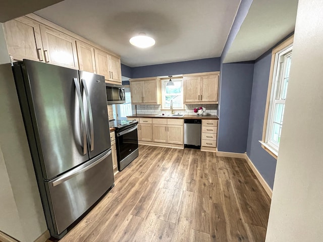 4241 Tyler St NE, Columbia Heights, MN 55421 - kitchen featuring appliances with stainless steel finishes, light brown cabinets, wood finished floors, dark countertops, and decorative backsplash
