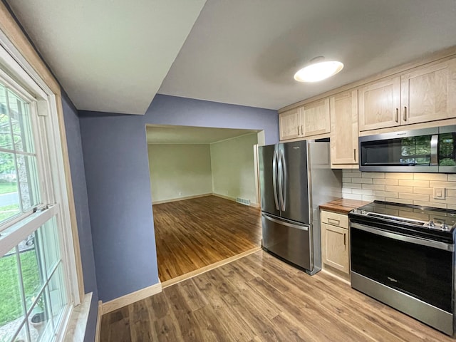 4241 Tyler St NE, Columbia Heights, MN 55421 - kitchen featuring stainless steel appliances, tasteful backsplash, light wood finished floors, wood counters, and open floor plan
