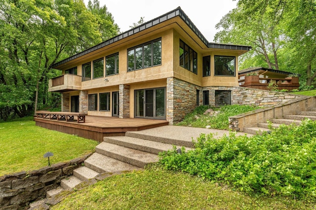 28647 State Highway 78, Otter Tail Twp, MN 56515 - back of house featuring a balcony, a yard, a wooden deck, stone siding, and stucco siding