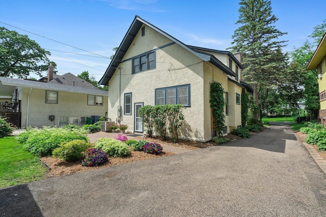 141 Rustic Ldg W, Minneapolis, MN 55419 - view of front of house featuring stucco siding, a patio, and a chimney