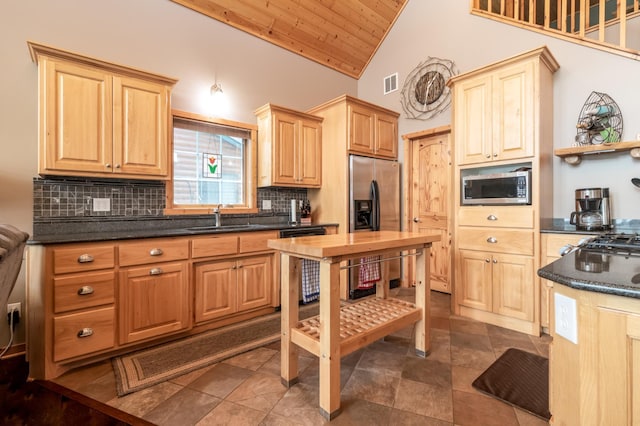 12088 Sylvan Dr SW, Pillager, MN 56473 - kitchen with stainless steel appliances, a sink, lofted ceiling, dark countertops, and tasteful backsplash