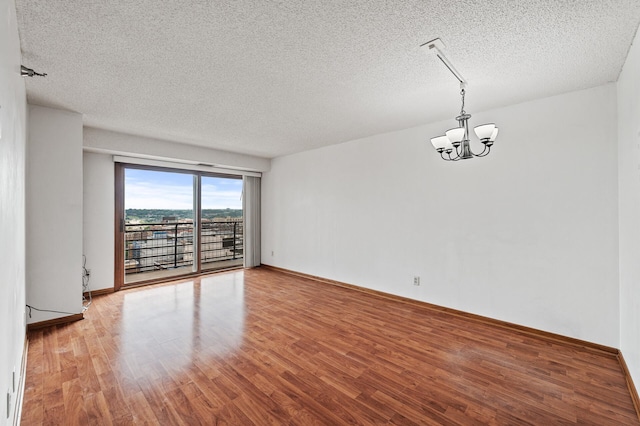 66 9th St E Unit 1806, Saint Paul, MN 55101 - unfurnished room with a textured ceiling, a chandelier, and wood finished floors
