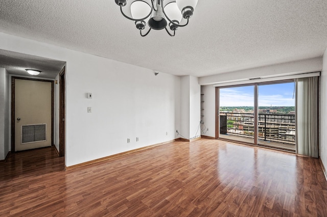 66 9th St E Unit 1806, Saint Paul, MN 55101 - unfurnished room featuring a textured ceiling, a chandelier, and wood finished floors