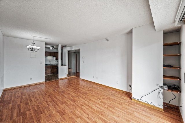 66 9th St E Unit 1806, Saint Paul, MN 55101 - unfurnished living room with a textured ceiling, light wood finished floors, and a chandelier