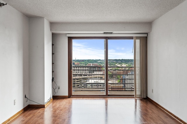 66 9th St E Unit 1806, Saint Paul, MN 55101 - empty room featuring wood finished floors, healthy amount of natural light, and a textured ceiling