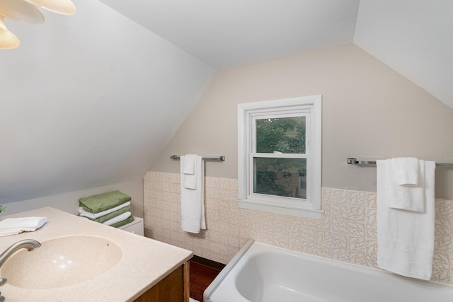 190 Annapolis St E, West Saint Paul, MN 55118 - full bath with tile walls, a bath, lofted ceiling, vanity, and a wainscoted wall