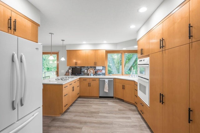 2434 Southcrest Ave E, Maplewood, MN 55119 - kitchen featuring white appliances, a peninsula, light wood-style flooring, decorative backsplash, and light countertops