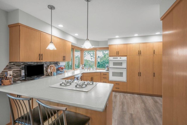 2434 Southcrest Ave E, Maplewood, MN 55119 - kitchen with a peninsula, white appliances, backsplash, light countertops, and decorative light fixtures