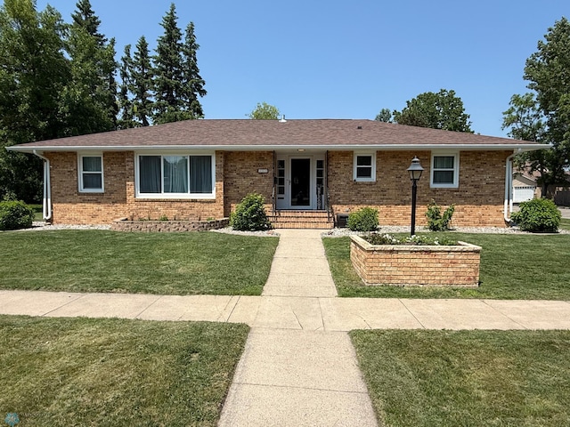 409 1st Ave E, Ada, MN 56510 - ranch-style home with brick siding, a front lawn, and a shingled roof