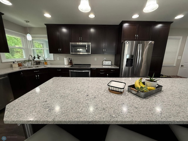409 1st Ave E, Ada, MN 56510 - kitchen featuring appliances with stainless steel finishes, light stone countertops, hanging light fixtures, recessed lighting, and a center island