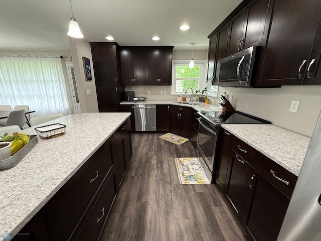 409 1st Ave E, Ada, MN 56510 - kitchen featuring stainless steel appliances, dark wood-style flooring, hanging light fixtures, dark brown cabinetry, and light stone countertops