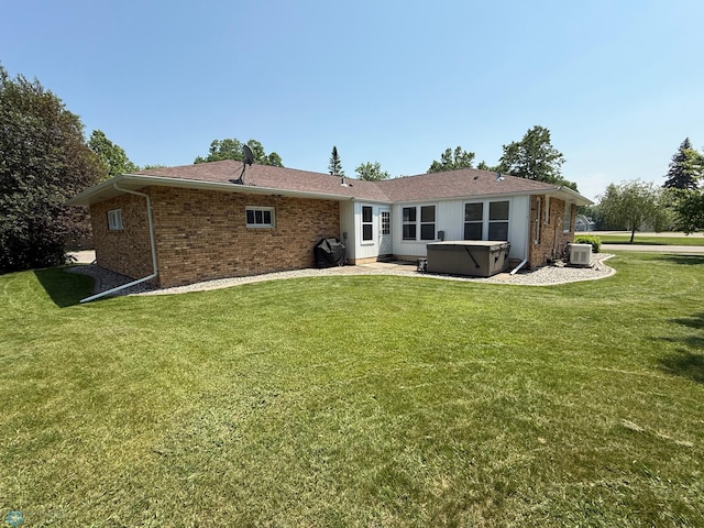 409 1st Ave E, Ada, MN 56510 - rear view of property featuring a hot tub, brick siding, and a lawn