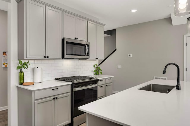 17983 Giants Way, Lakeville, MN 55044 - kitchen with stainless steel appliances, gray cabinets, decorative backsplash, light countertops, and recessed lighting