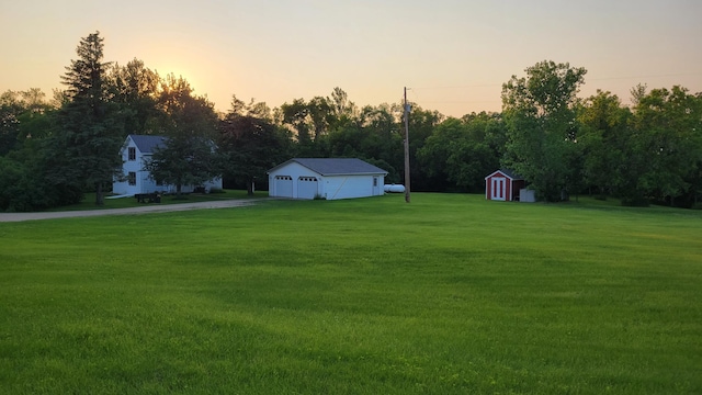 112 240th St N, Eglon Twp, MN 56549 - view of green lawn featuring a detached garage, driveway, and a storage shed