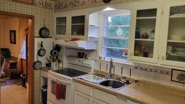 112 240th St N, Eglon Twp, MN 56549 - kitchen featuring electric stove, tasteful backsplash, extractor fan, wallpapered walls, and white cabinetry