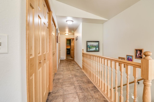 2607 Forest View Dr NE, Bemidji, MN 56601 - hall with an upstairs landing, vaulted ceiling, and stone finish floors