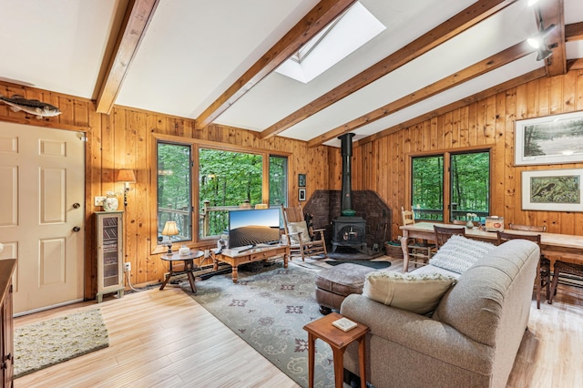2225 Antler Lake Ct, Milltown, WI 54858 - living area featuring a wood stove, wooden walls, light wood-style flooring, and a skylight