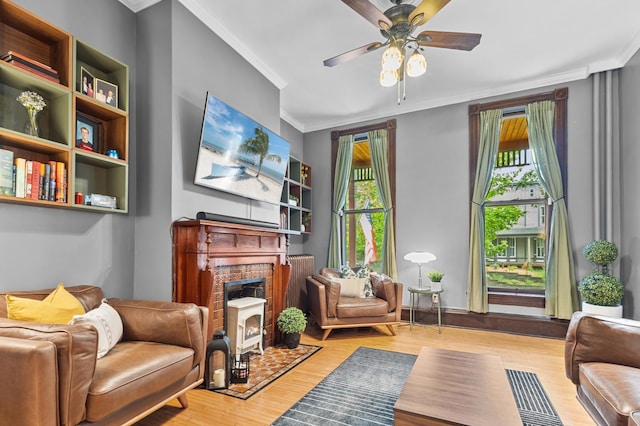 737 5th St E, Saint Paul, MN 55106 - living area featuring healthy amount of natural light, wood finished floors, ornamental molding, a ceiling fan, and a fireplace with flush hearth