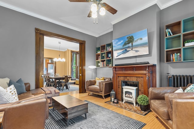 737 5th St E, Saint Paul, MN 55106 - living area with radiator, hardwood / wood-style flooring, a chandelier, crown molding, and a ceiling fan