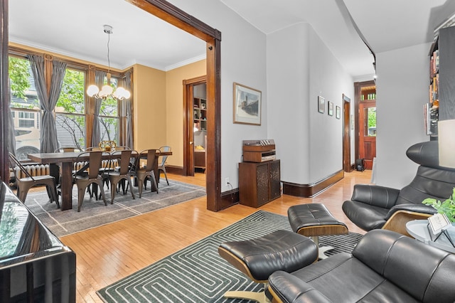 737 5th St E, Saint Paul, MN 55106 - living area with light wood-type flooring, a chandelier, and crown molding