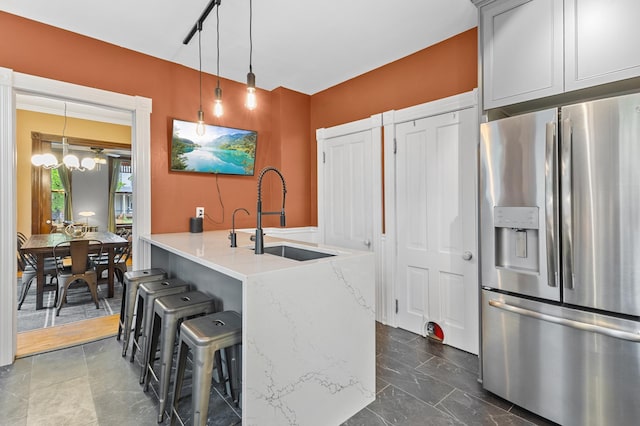 737 5th St E, Saint Paul, MN 55106 - kitchen featuring stainless steel fridge with ice dispenser, a kitchen breakfast bar, pendant lighting, dark marble finish floors, and light stone counters