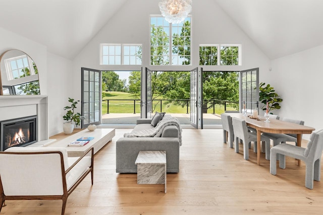 4603 Merilane Ave, Edina, MN 55436 - living room with high vaulted ceiling, a glass covered fireplace, light wood finished floors, and a chandelier