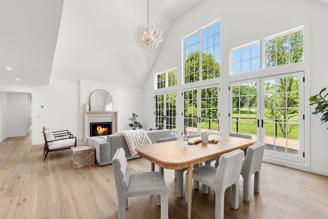 4603 Merilane Ave, Edina, MN 55436 - dining area with high vaulted ceiling, light wood-style flooring, a lit fireplace, a chandelier, and recessed lighting
