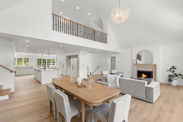 4603 Merilane Ave, Edina, MN 55436 - dining room featuring a high ceiling, a warm lit fireplace, light wood-style floors, a chandelier, and recessed lighting
