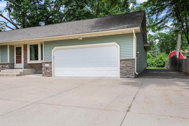 2131 111th Ln NW, Coon Rapids, MN 55433 - view of front facade with stone siding, driveway, roof with shingles, and a garage