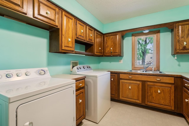 2131 111th Ln NW, Coon Rapids, MN 55433 - laundry area with washer and dryer, cabinet space, a textured ceiling, and light flooring