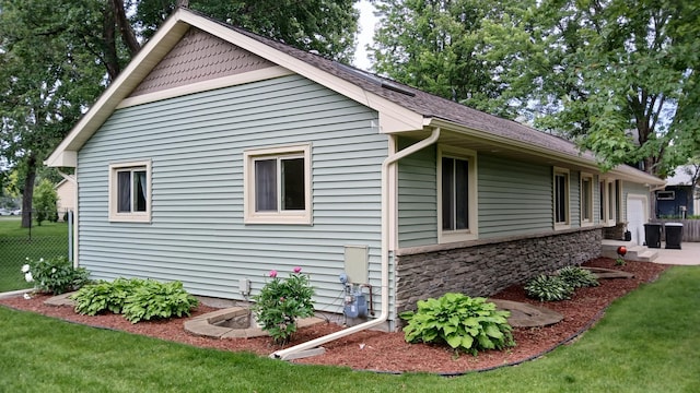 2131 111th Ln NW, Coon Rapids, MN 55433 - view of side of home with stone siding and a garage