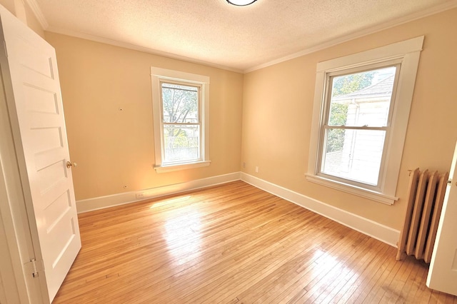 3140 Fremont Ave S, Minneapolis, MN 55408 - unfurnished room featuring radiator, plenty of natural light, light wood-type flooring, ornamental molding, and a textured ceiling