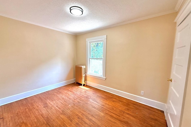 3140 Fremont Ave S, Minneapolis, MN 55408 - spare room featuring radiator heating unit, crown molding, wood-type flooring, and a textured ceiling