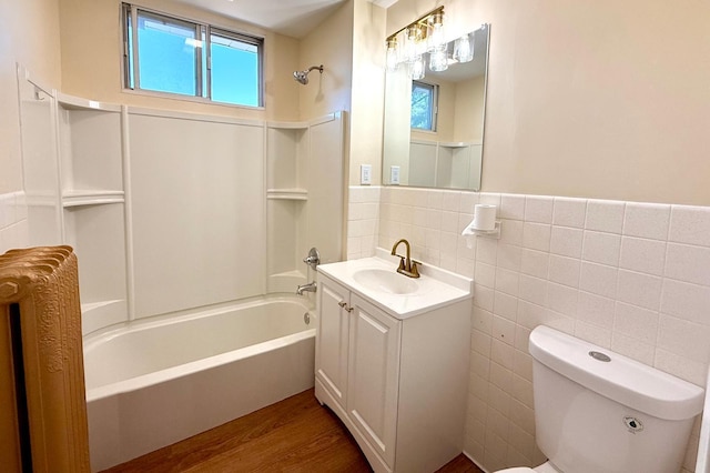 3140 Fremont Ave S, Minneapolis, MN 55408 - bathroom featuring vanity, wood finished floors, washtub / shower combination, tile walls, and wainscoting
