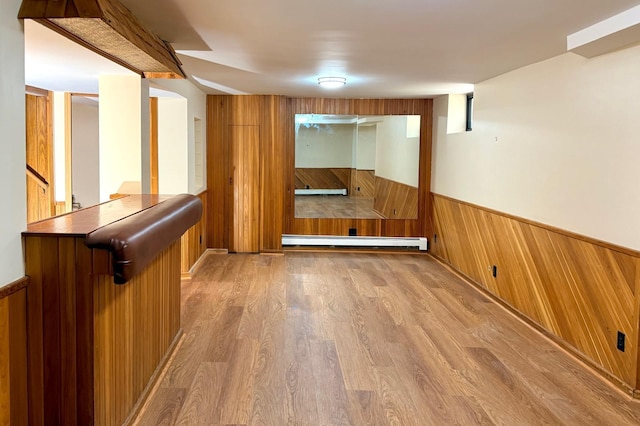 3140 Fremont Ave S, Minneapolis, MN 55408 - spare room with wooden walls, wainscoting, baseboard heating, wood finished floors, and stairs