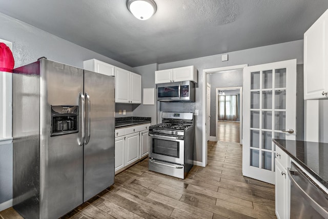 984 Iglehart Ave, Saint Paul, MN 55104 - kitchen with appliances with stainless steel finishes, dark wood-type flooring, and white cabinetry
