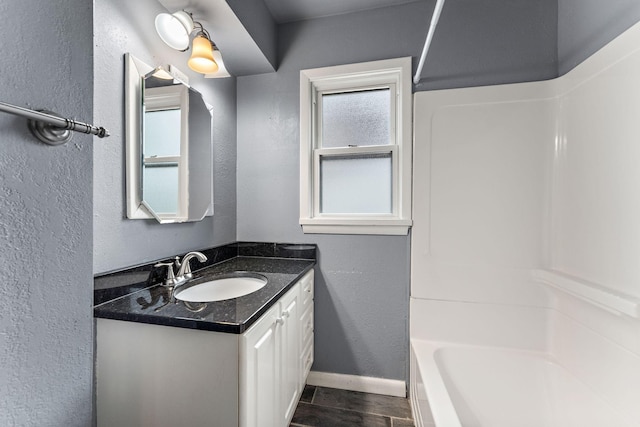 984 Iglehart Ave, Saint Paul, MN 55104 - full bath with vanity, a textured wall, wood finished floors, and bathtub / shower combination