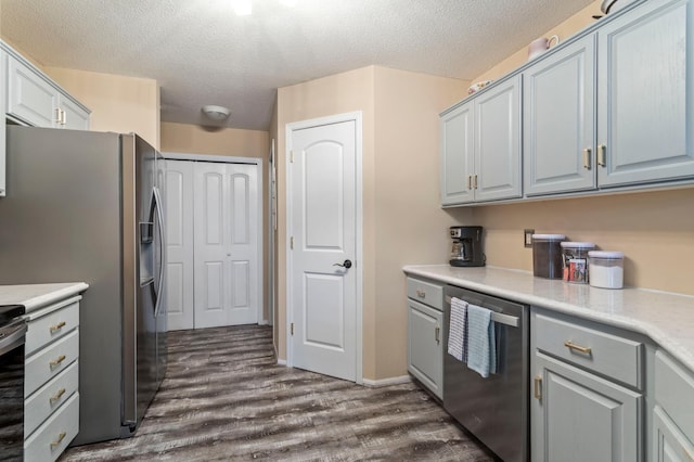 8475 121st Ave N, Champlin, MN 55316 - kitchen featuring stainless steel appliances, a textured ceiling, dark wood-style flooring, gray cabinetry, and light countertops