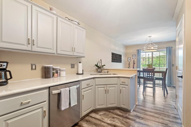 8475 121st Ave N, Champlin, MN 55316 - kitchen featuring stainless steel dishwasher, wood finished floors, a peninsula, white cabinetry, and light countertops