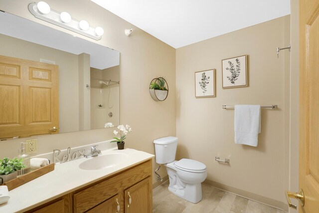 5650 Boone Ave N, New Hope, MN 55428 - bathroom with vanity, toilet, baseboards, and a shower