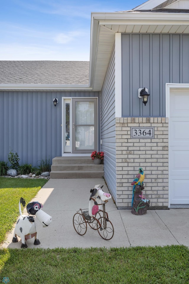 3364 27th St S, Moorhead, MN 56560 - view of exterior entry featuring board and batten siding, roof with shingles, and a garage