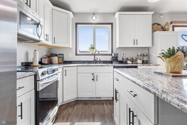 3364 27th St S, Moorhead, MN 56560 - kitchen with appliances with stainless steel finishes, dark wood-type flooring, white cabinets, and light stone counters