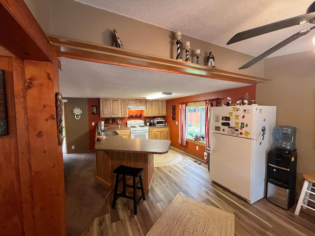 5940 150th Ave NE, New London Twp, MN 56288 - kitchen with white appliances, a textured ceiling, a peninsula, light wood-type flooring, and a breakfast bar area