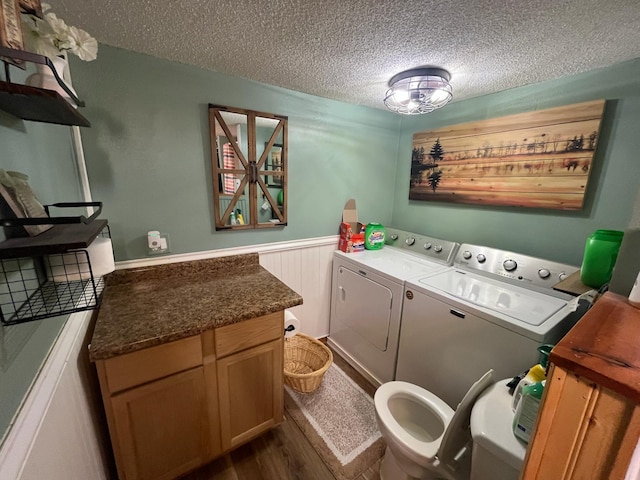 5940 150th Ave NE, New London Twp, MN 56288 - laundry area featuring washing machine and clothes dryer, a textured ceiling, wainscoting, dark wood finished floors, and cabinet space