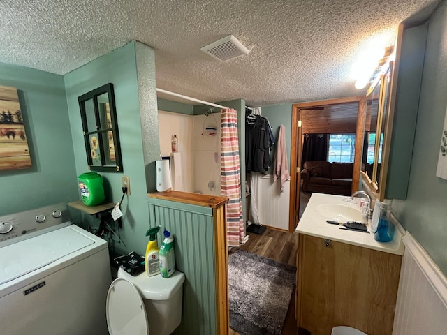 5940 150th Ave NE, New London Twp, MN 56288 - full bathroom with washer / clothes dryer, a textured ceiling, vanity, wood finished floors, and a shower with curtain